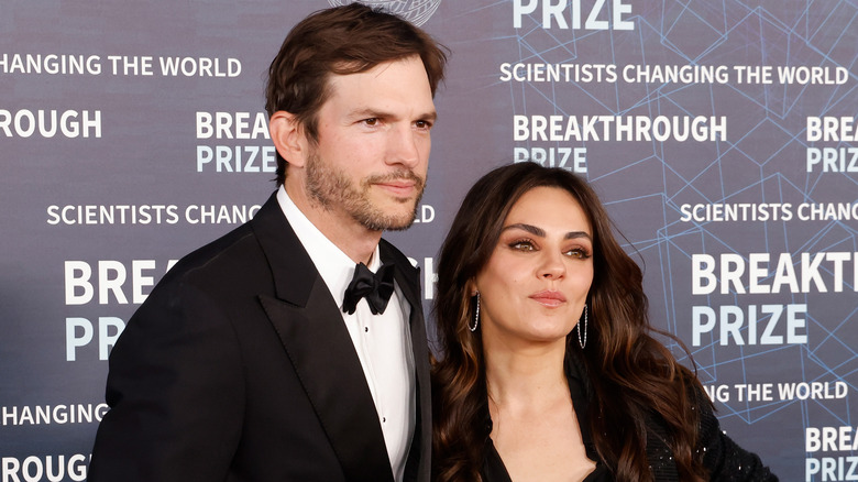 Ashton Kutcher and Mila Kunis posing together on the red carpet.
