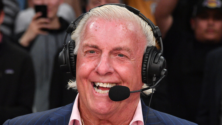 Ric Flair at an event, speaking with microphone headset