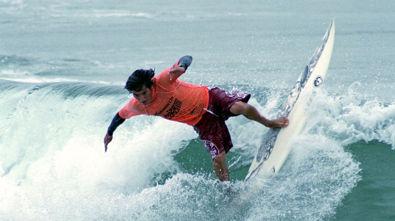 Mikala Jones surfs a big wave