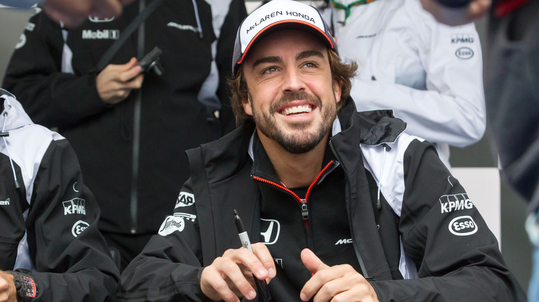 Fernando Alonso smiling, looking up