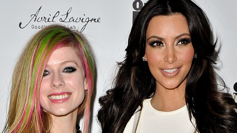 Avril Lavigne smiling with Kim Kardashian on the red carpet