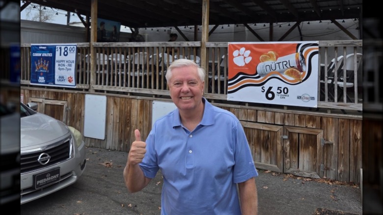 Lindsey Graham posing in front of a restaurant.