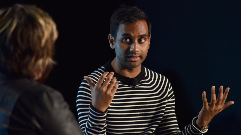 Aziz Ansai speaking to someone, hands up