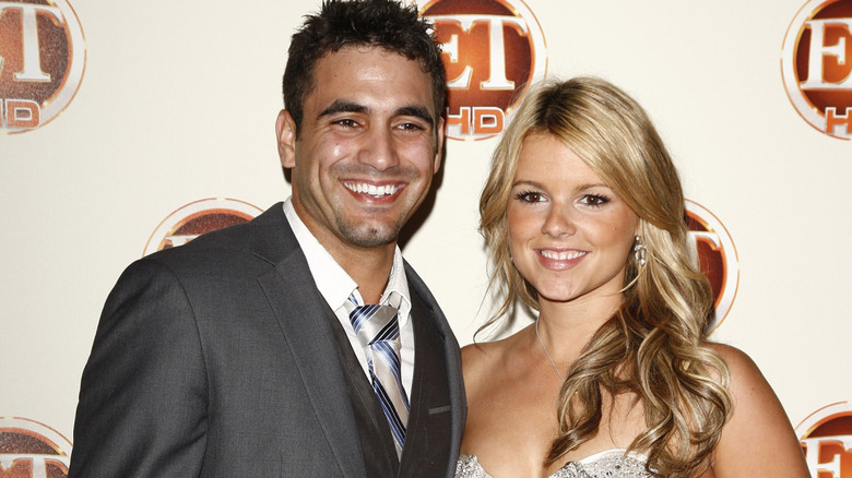 Roberto Martinez and Ali Fedotowsky posing in front of an ET background