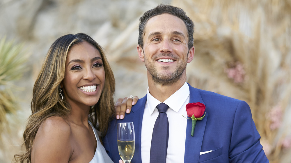 Tayshia Adams with champagne in hand with Zac Clark