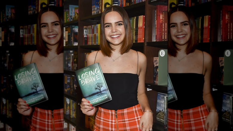 Bailee Madison posing with her book, Losing Brave