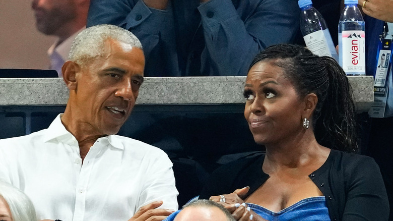 Barack and Michelle Obama attending event having conversation
