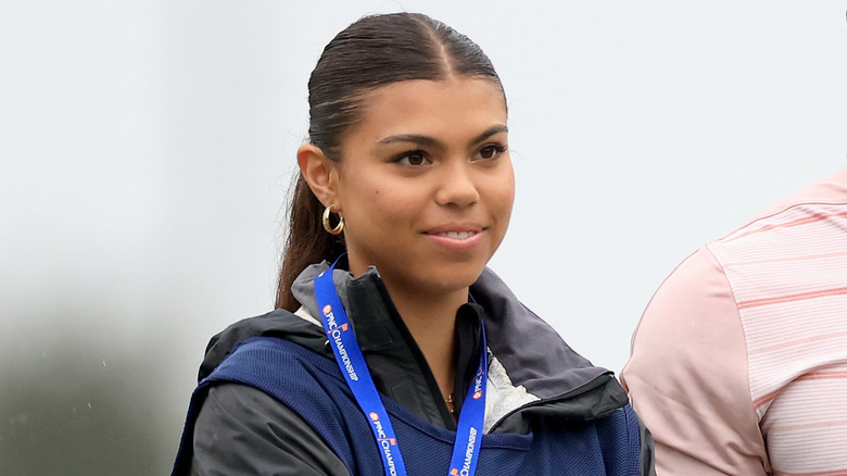 Sam Woods smiles while caddying for her dad.