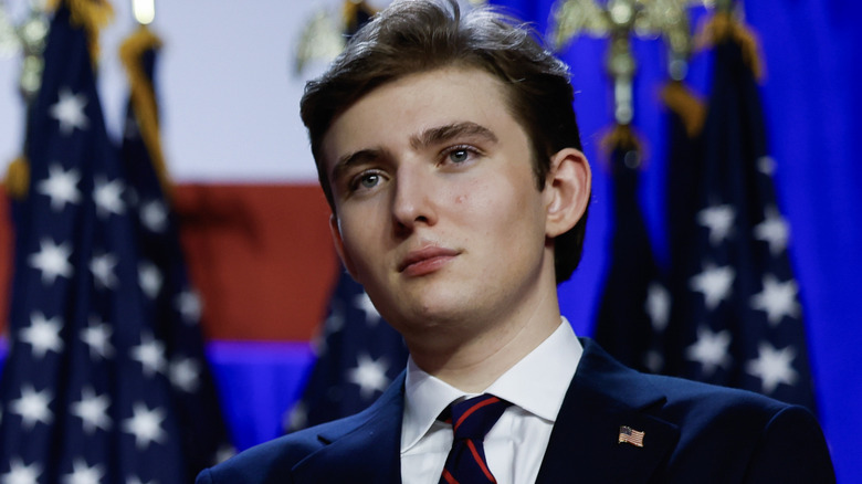 Barron Trump on stage with American flags behind him