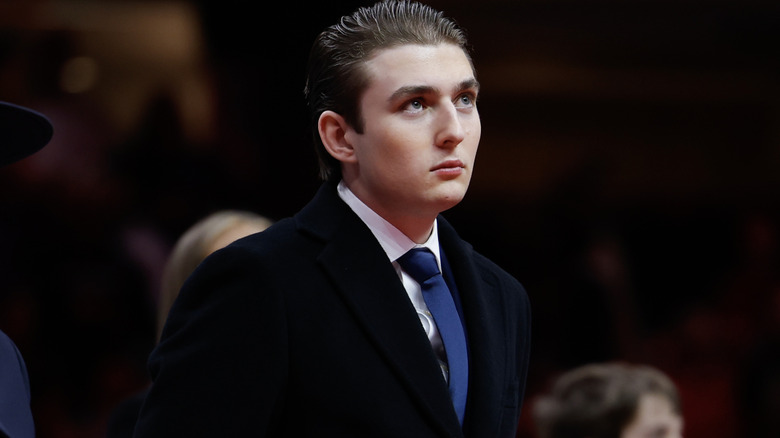Barron Trump in a suit and blue tie in attendance at a large event