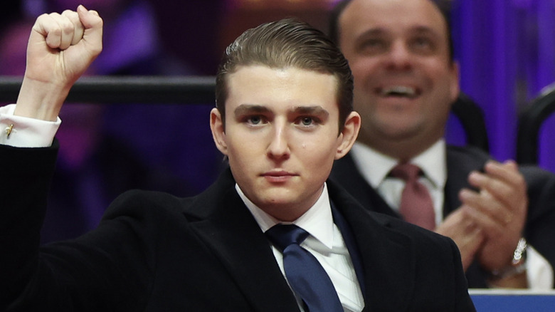 Barron Trump slightly smiling and raising his fist