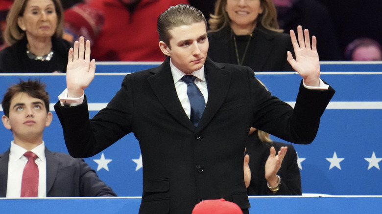 Barron Trump holds his hands up at the inauguration.