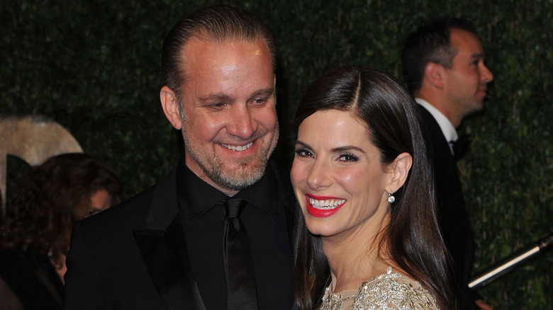 Jesse James smiling with Sandra Bullock