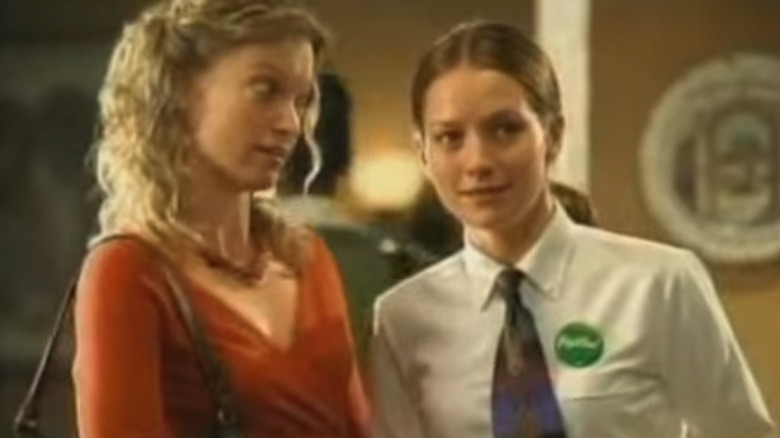 Becki Newton leans toward a castmate, sporting a shirt and tie.