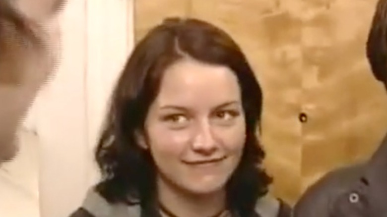 Becki Newton looks at a castmate, sporting a soft smile.