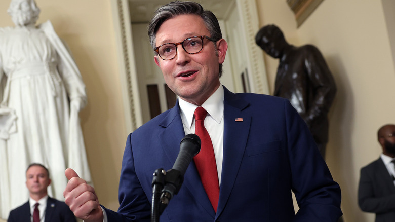 Mike Johnson speaking animatedly into a microphone.