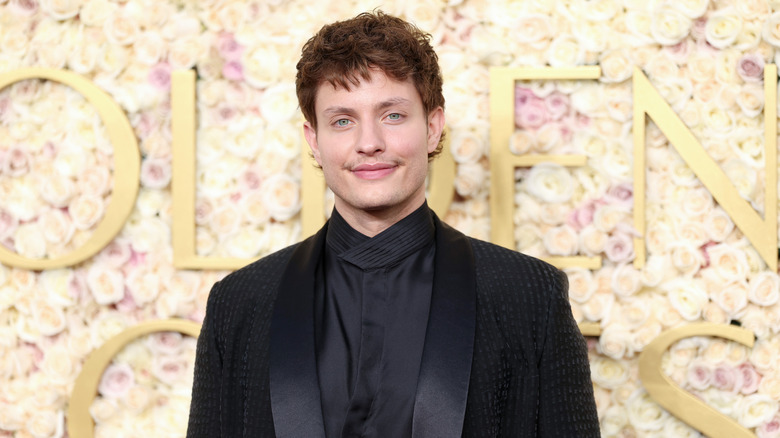 Matt Rife in front of a flower wall at an event