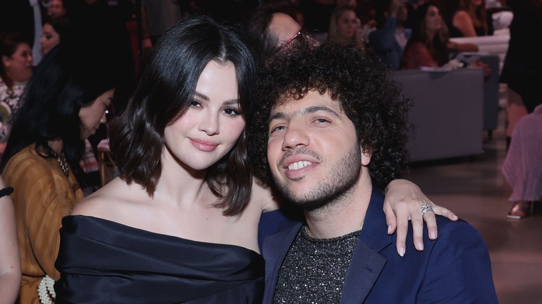 Selena Gomez and Benny Blanco seat with arms around each other in October 2024