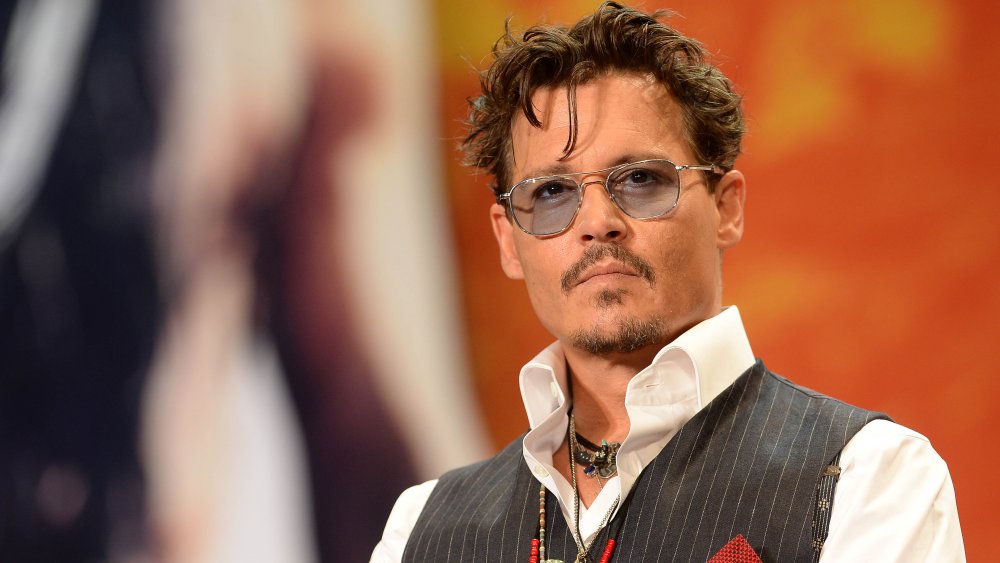 Johnny Depp in white shirt, grey vest, and grey-tinted sunglasses