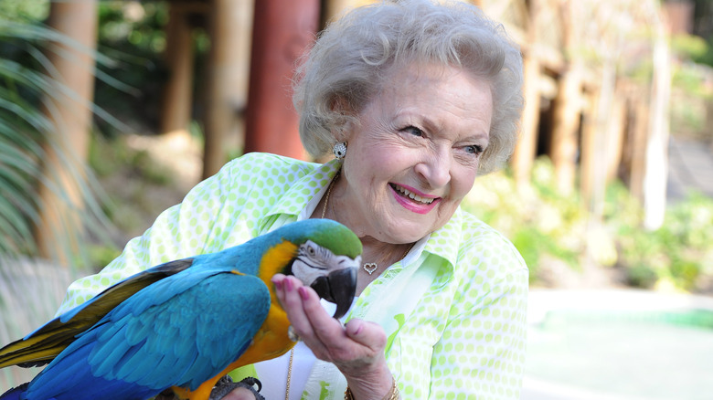 Betty White holds a parrot 