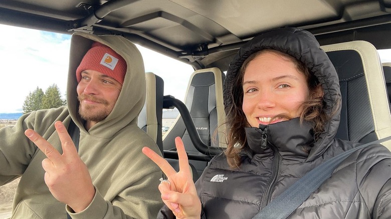 Luke Grimes and Bianca Rodrigues pose in a 4x4