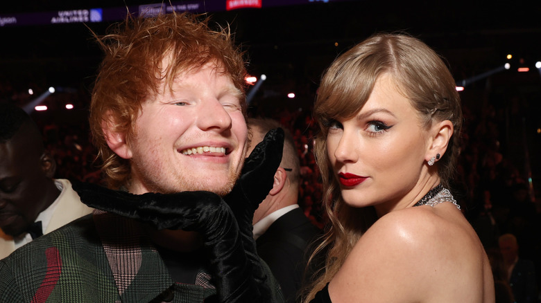 Taylor Swift placing her hands under Ed Sheeran's twin.