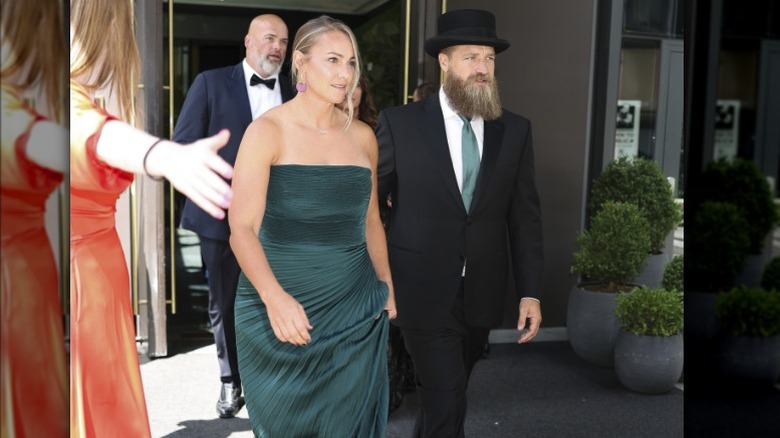 Liza Barber wearing a green strapless dress and Ryan Fitzpatrick wearing a top hat and green tie.