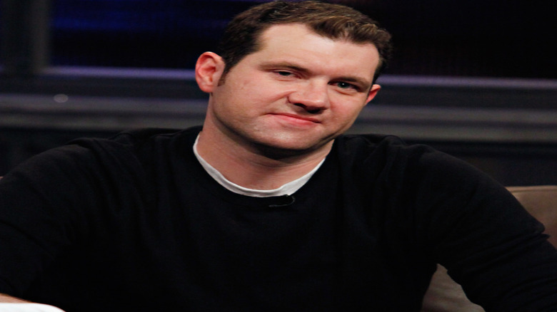 Billy EIchner smiling in sweater