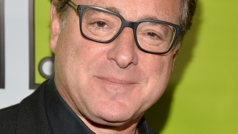 Bob Saget poses in black-frame glasses