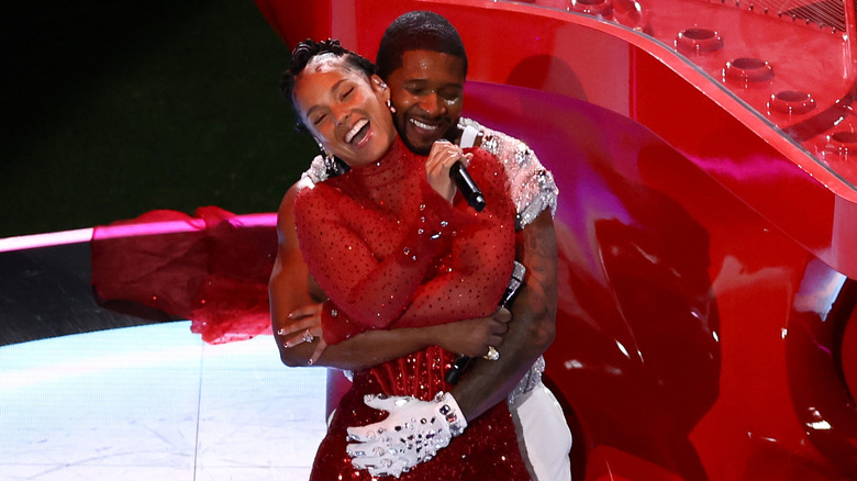 Usher embracing Alicia Keys on stage