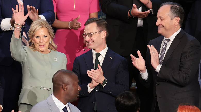 Doug Emhoff smiling as Jill Biden waves