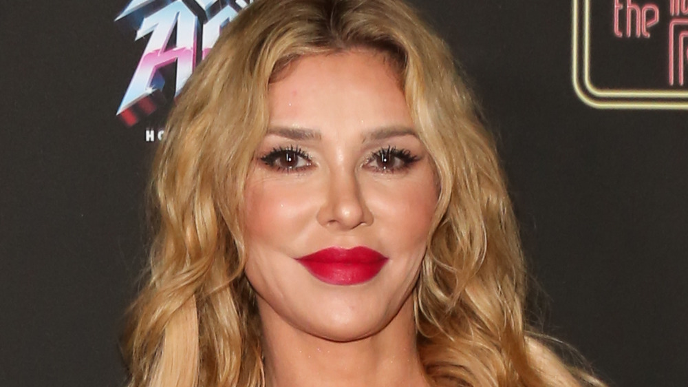 Brandi Glanville, smiling, red lipstick, blond hair down, leopard jacket, red carpet 2020