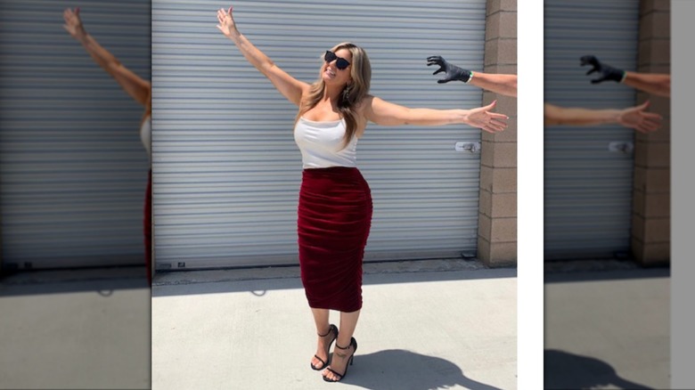 Wearing a two-tone style outfit, Brandi Passante stretches her arms wide.