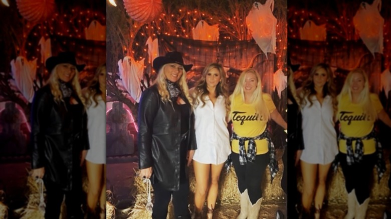 Sporting a white shirt dress, Brandi Passante strikes a pose between two friends.