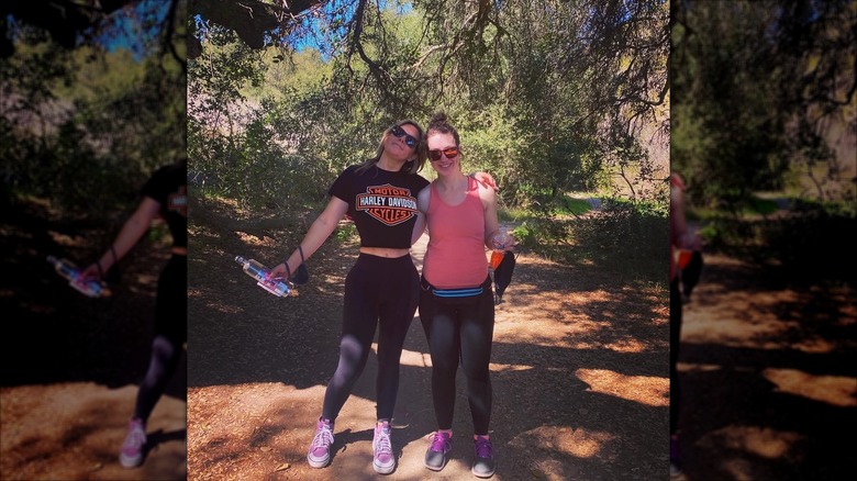 Brandi Passante has her arm wrapped around a friend while out in the woods.