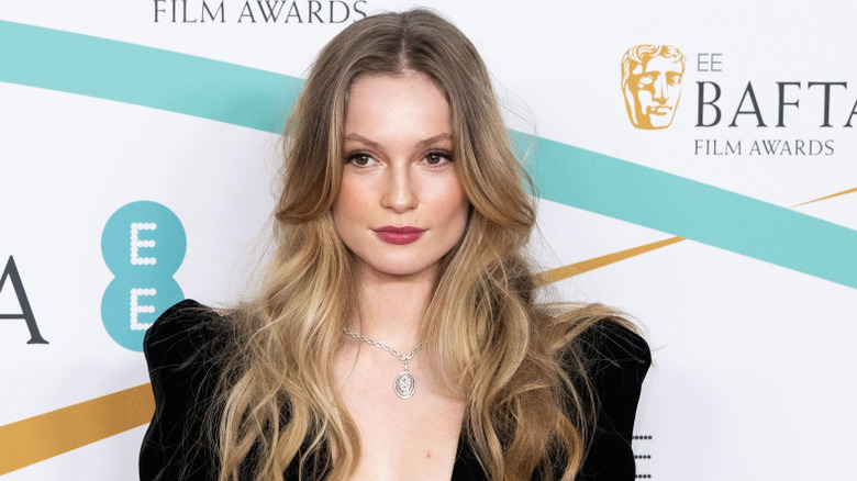 Wearing wavy hair and a black outfit, Hannah Dodd gazes away from the lens.