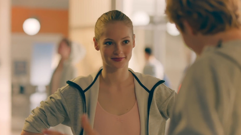 Hannah Dodd smiles softly with her hands placed on her waist.