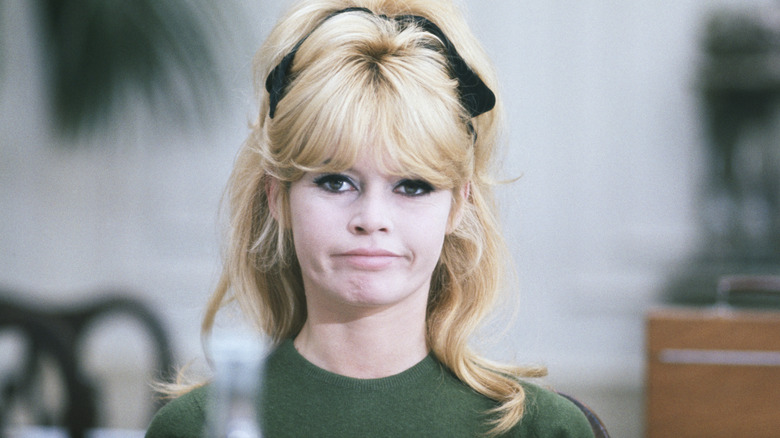 Brigitte Bardot posing in a green shirt