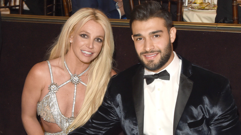 Britney Spears and Sam Asghari smiling at a table together
