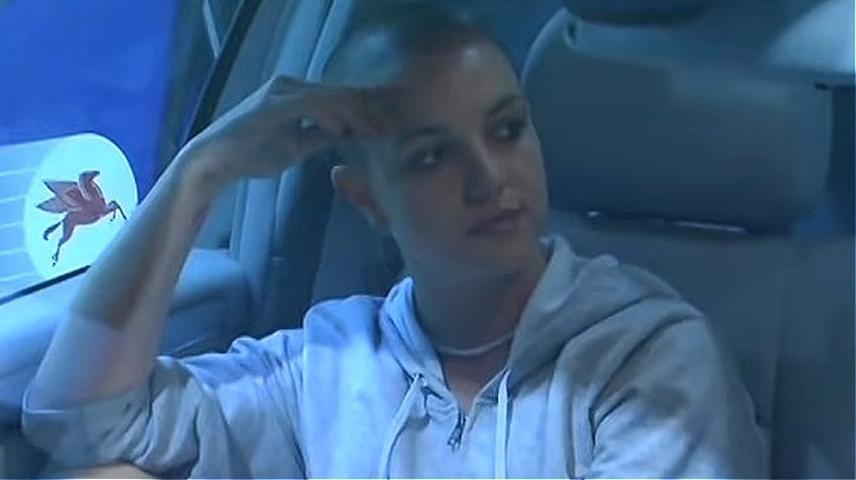 Britney sitting in car with shaved head