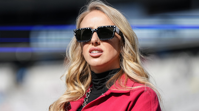 Brittany Mahomes wearing sunglasses anda red jacket