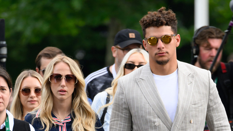 Brittany and Patrick Mahomes walking while wearing sunglasses