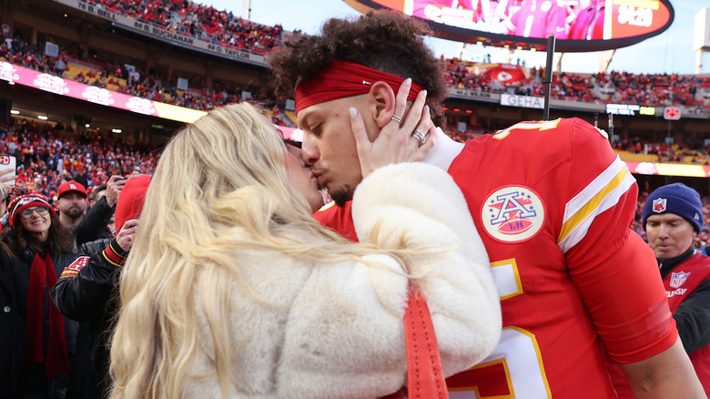 Brittany and Patrick Mahomes kissing on the field at a Chiefs game