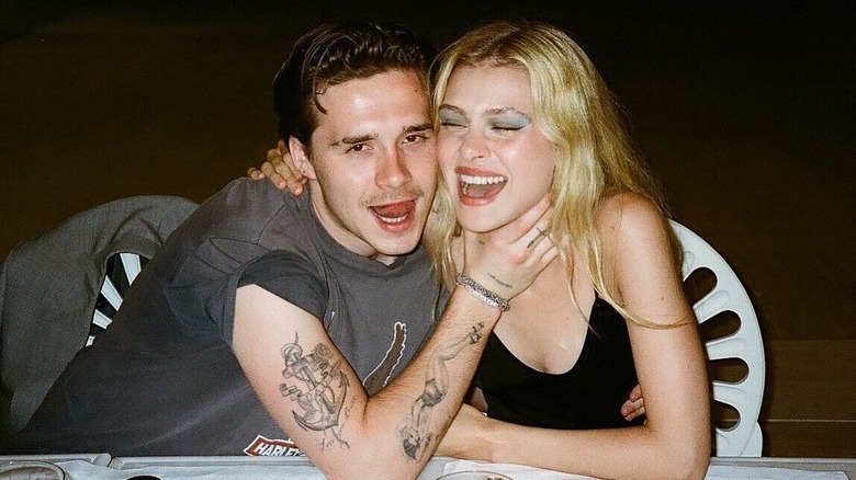 Brooklyn Beckham with hand around Nicola Peltz's neck