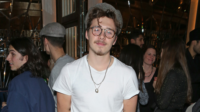 Brooklyn Beckham wearing cap and glasses