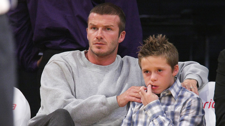 David Beckham with hand on Brooklyn Beckham's shoulder