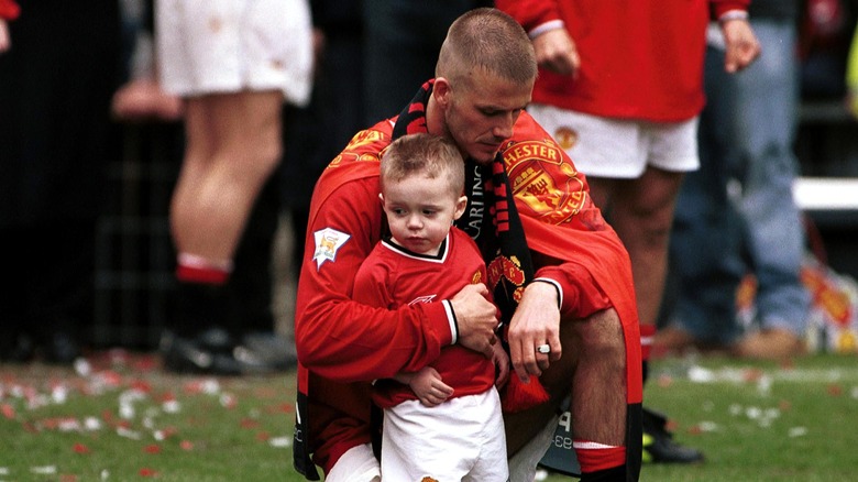David Beckham kneeling with Brooklyn Beckham