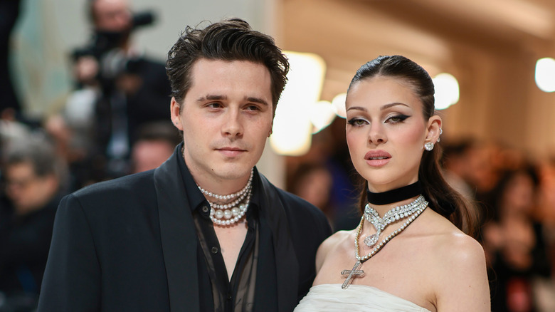 Brooklyn Beckham looks away from the lens as Nicola Peltz gives the camera a fierce stare.