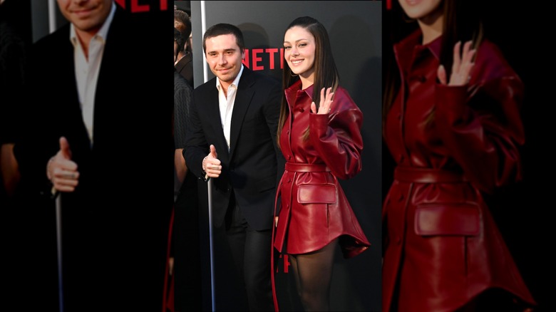 Brooklyn Beckham gives a thumbs-up and Nicola Peltz waves at the "Beckham" Netflix Premiere at The Curzon Mayfair