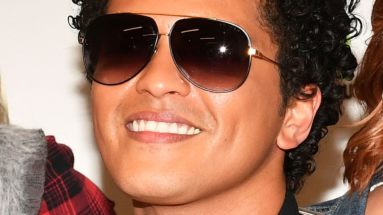 Bruno Mars smiling in sunglasses